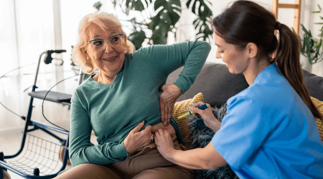Pflegekraft verabreicht einer Seniorin eine Insulininjektion